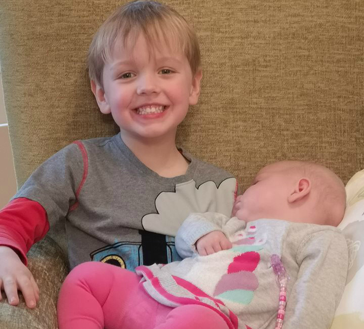 Oscar cuddling his cousin, Erin