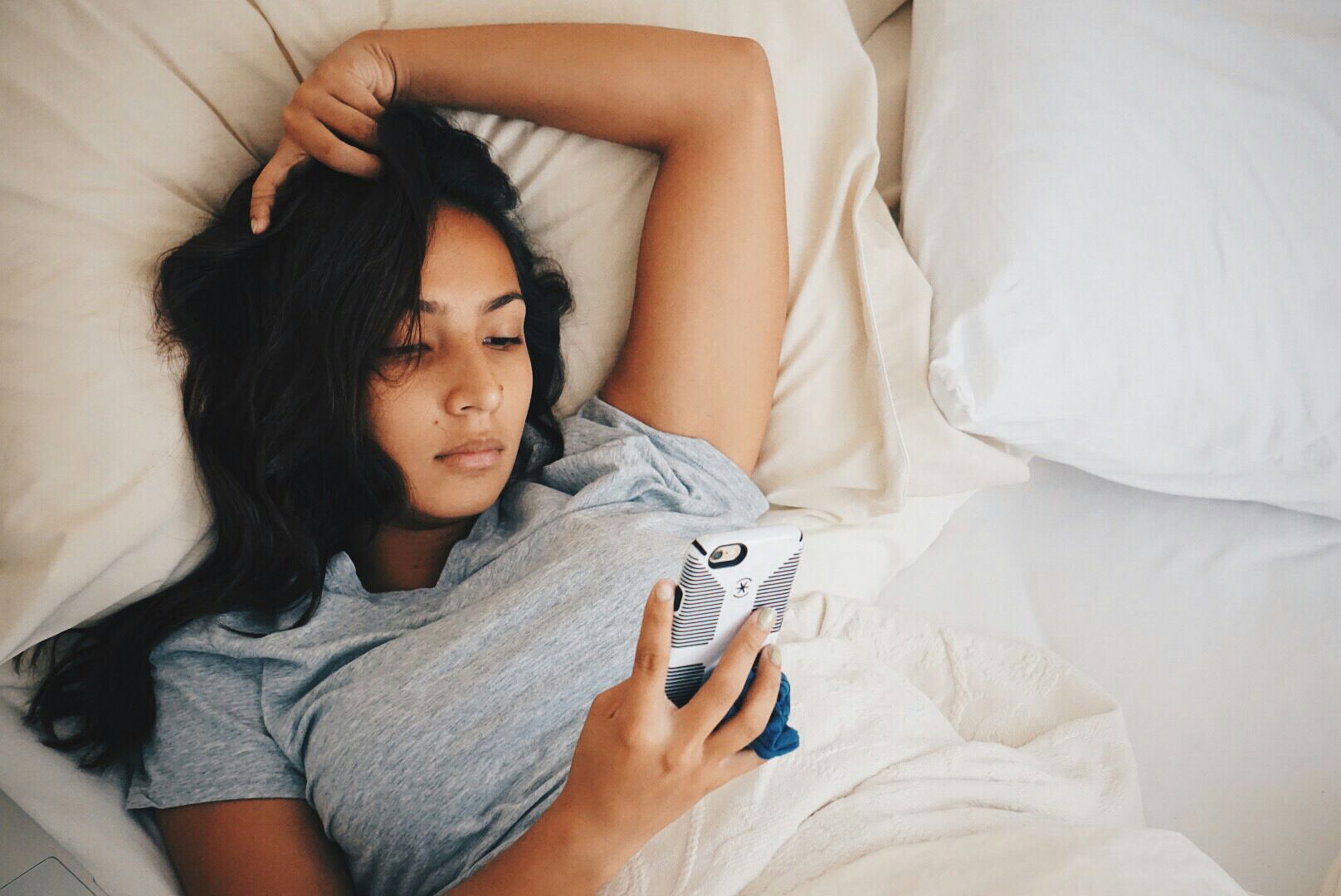 Woman looking at her phone in bed