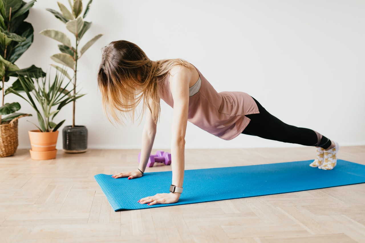 Woman working out on a blue yoga mat Woman working out on a blue yoga mat