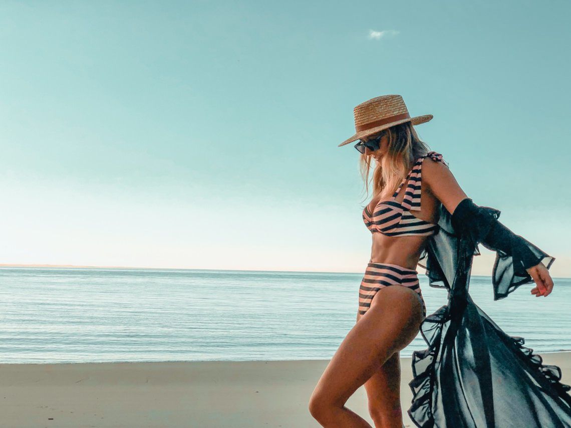 Woman wearing a striped bikini and a beach coverup Woman wearing a striped bikini and a beach coverup